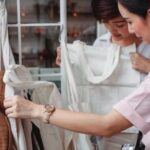 Sustainable Fashion Revolution. - Trendy young Asian women choosing cotton bags in fashion boutique
