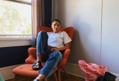 Clothing Exchange - woman sitting on sofa chair beside window