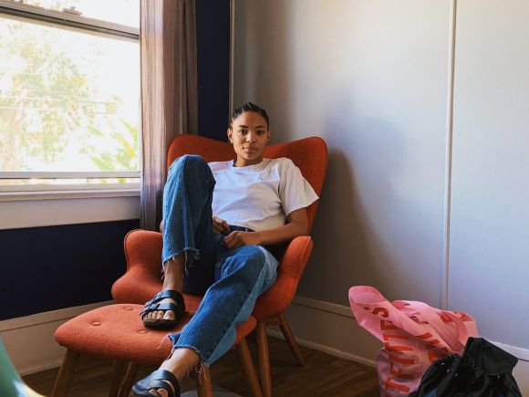 Clothing Exchange - woman sitting on sofa chair beside window